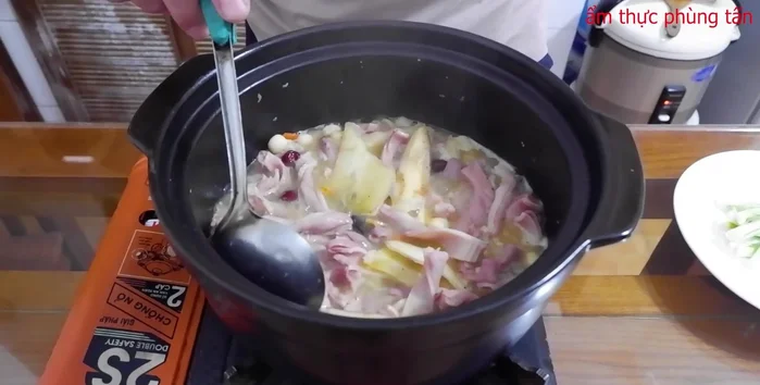 Hoàn thiện: Sau 35 phút, tắt bếp, cho hành lá vào, múc ra thưởng thức.