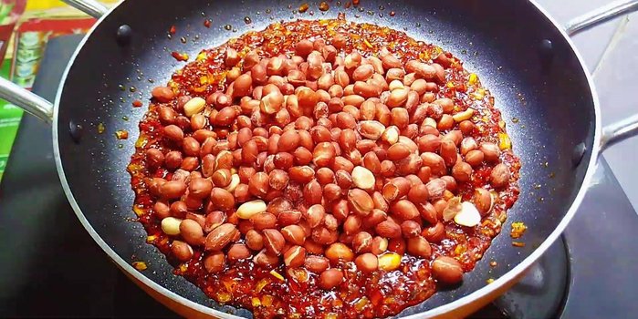 Rim đậu phộng: Cho đậu phộng rang vào chảo, rim với lửa lớn cho đến khi đậu phộng thấm gia vị và nước mắm đường cạn hết.