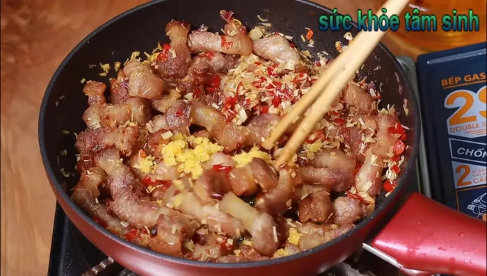 Cho thịt vào lại chảo, thêm đường, trộn đều.