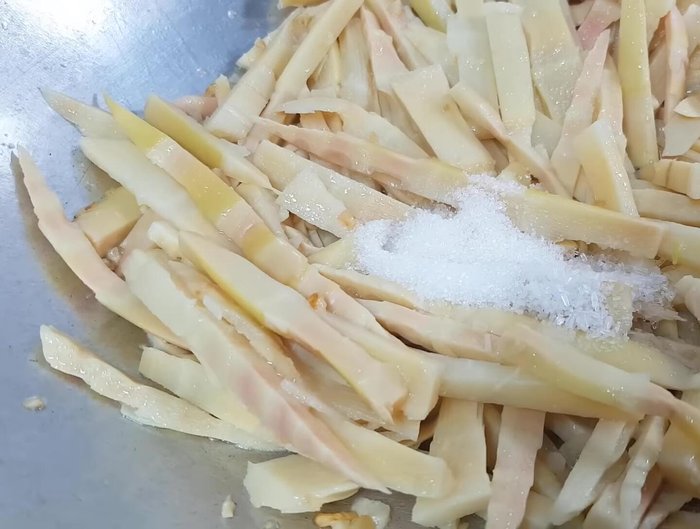 Thêm gia vị vào xào cùng măng: muối, bột ngọt, đường, hạt nêm, nước mắm. Xào khoảng 2 phút cho măng thấm gia vị rồi tắt bếp.