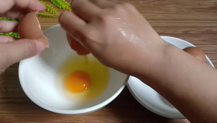 Đập 4 quả trứng gà vào tô, tách riêng lòng đỏ và lòng trắng. (57.93)