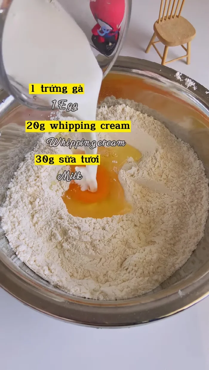 Thêm trứng gà, sữa tươi và tinh chất vani, trộn đều. Có thể dùng máy trộn để nhanh hơn.