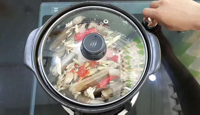 Đậy nắp thố, bật bếp lớn, hấp cho đến khi ốc chín tới (khoảng 10 phút).