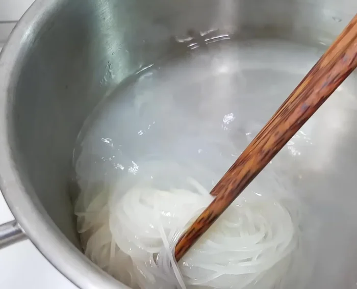Trụng hủ tiếu qua nước sôi cho mềm. Múc hủ tiếu ra tô, chan nước dùng, trang trí với hành lá, hành phi, rau sống, ớt, tỏi.