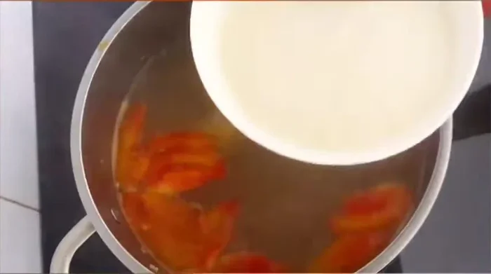 Hòa tan cơm mẻ với nước lọc và đường, rồi cho từ từ vào nồi nước lẩu đến khi đạt độ chua mong muốn.