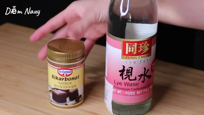 Chuẩn bị nước ngâm nếp: Nếu dùng nước tro tàu, trộn 50ml nước tro tàu với 500ml nước. Nếu dùng muối nở, hòa tan 10g muối nở trong 700ml nước, đun sôi trên lửa lớn trong 5 phút rồi để nguội. (54.57, 94.99)