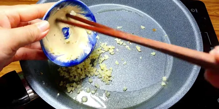 Đổ bớt dầu ăn trong chảo, thêm 3 muỗng canh dầu ăn, phi thơm hành tím và tỏi băm.