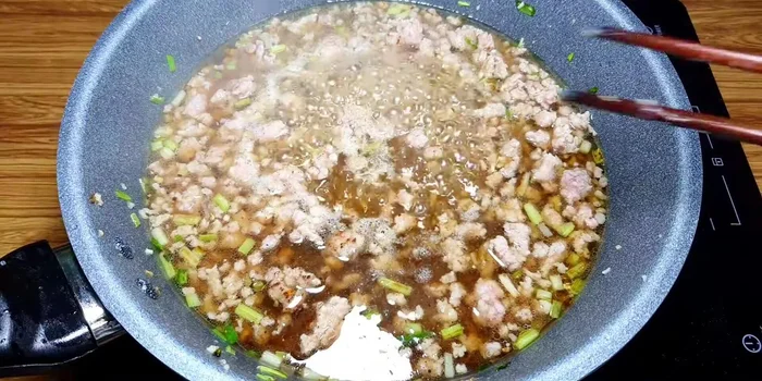 Đổ hỗn hợp gia vị đã pha vào chảo thịt băm, đun sôi trong 3 phút.