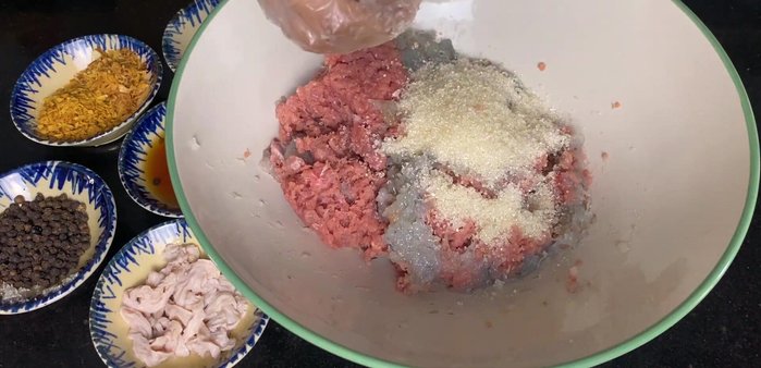 Trộn đều thịt, tôm xay, 75g đường còn lại, tỏi phi, hành phi, tiêu, muối, rượu Mai Quế Lộ.