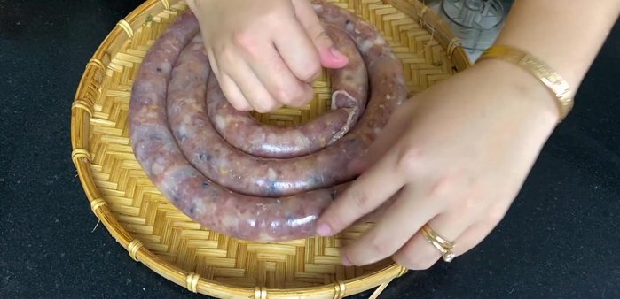 Chia lạp xưởng thành từng đoạn vừa ăn, buộc chặt bằng dây cước.