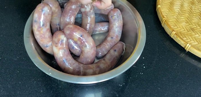 Nhúng lạp xưởng vào rượu trắng để khử trùng và chống ruồi muỗi.