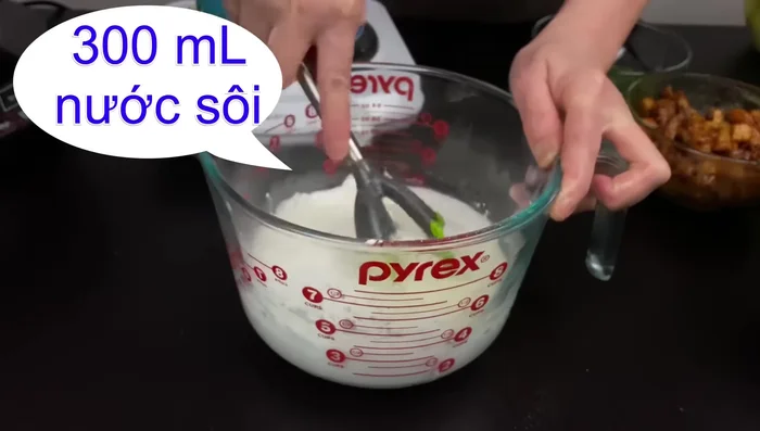 Đổ từ từ 300ml nước sôi vào hỗn hợp bột, khuấy đều đến khi bột hơi sệt (không quá đặc).
