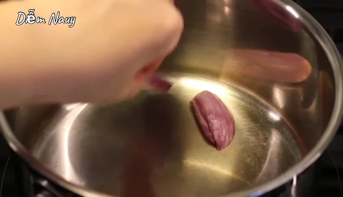 Cho hành tím, gừng vào nồi nước dùng đang sôi, xào cho thơm.