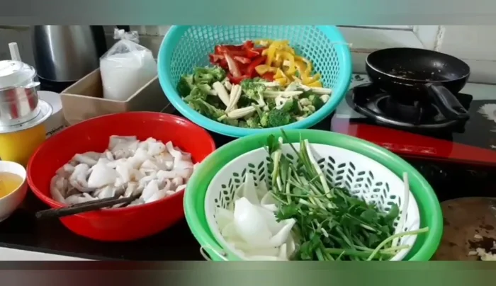 Chuẩn bị nguyên liệu: Sơ chế mực, bông cải xanh, ớt chuông. (Thời gian chuẩn bị không được nêu rõ trong transcript)