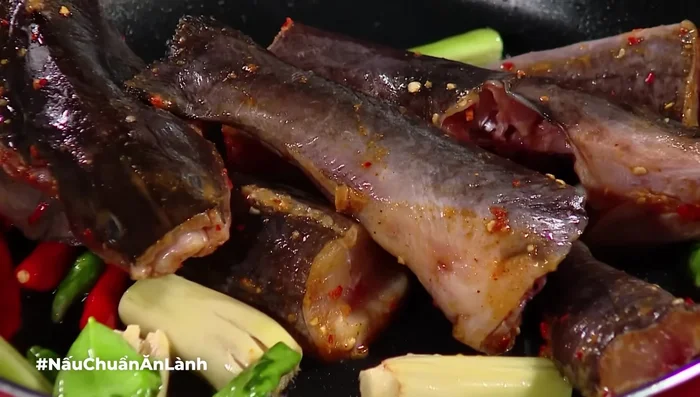 Cho cá vào chảo, xào cho cá thấm gia vị và không bị tanh.