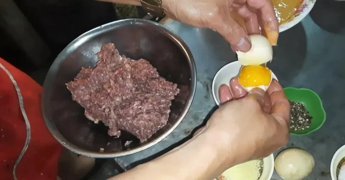 Đập trứng: Lấy lòng đỏ trứng gà cho vào nước dùng, khuấy đều.