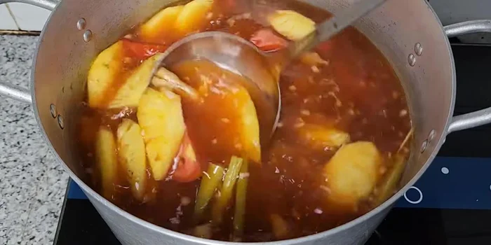 Cho khóm và cà chua vào nấu khoảng 2 phút cho sôi lại rồi tắt bếp.