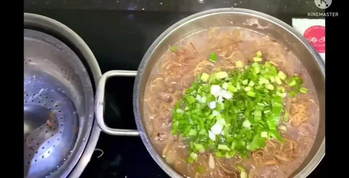 Thêm ngò gai và hành vào, tắt bếp.