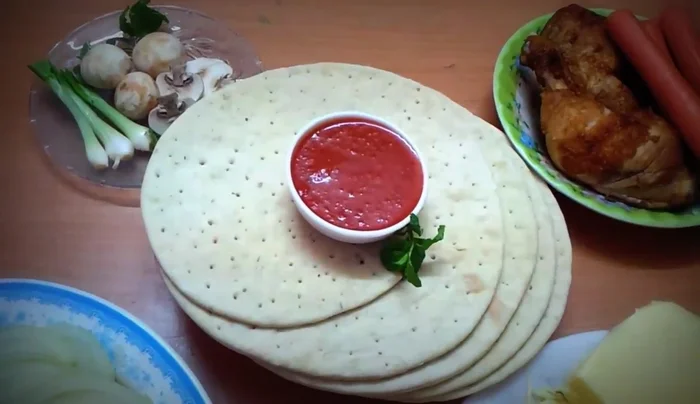Trải đế pizza ra khay nướng.