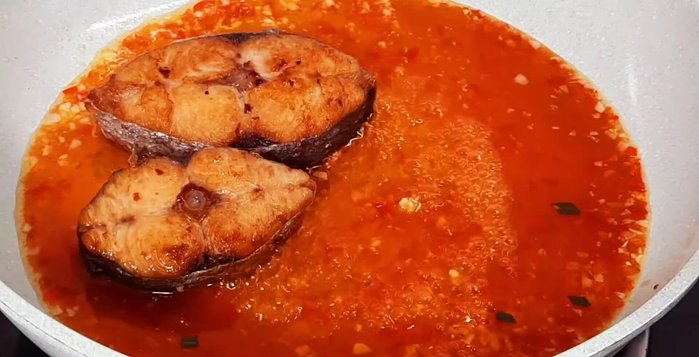 Cho cá thu đã chiên vào chảo, đảo đều để cá thấm nước sốt.