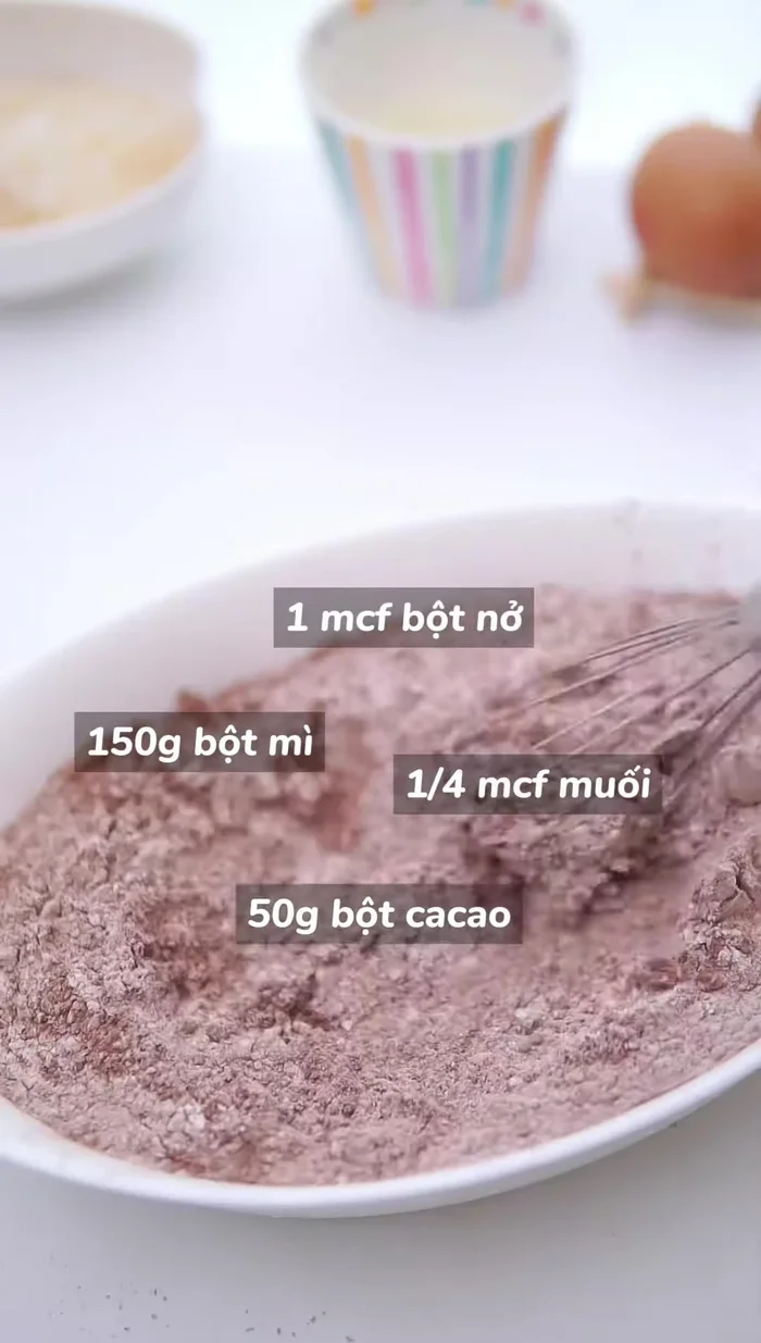 Trộn hỗn hợp bột: Cho bột mì, bột ca cao, bột nở và muối vào âu trộn, khuấy đều.