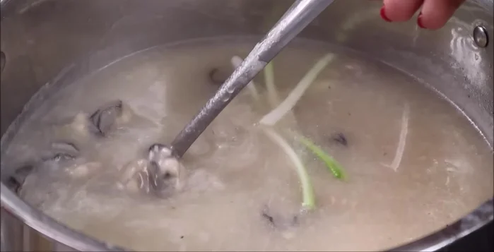Cho hành lá vào, múc cháo ra tô, rắc tiêu xay lên trên.