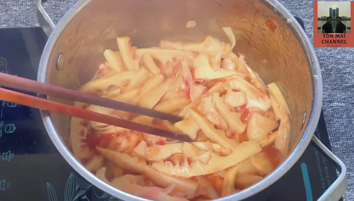 Nấu canh: Đổ nước vào nồi măng đang xào, đun sôi. Cho rươi đã ướp vào, khuấy nhẹ. Thêm vỏ quýt và ớt vào. Đun sôi khoảng 5 phút.