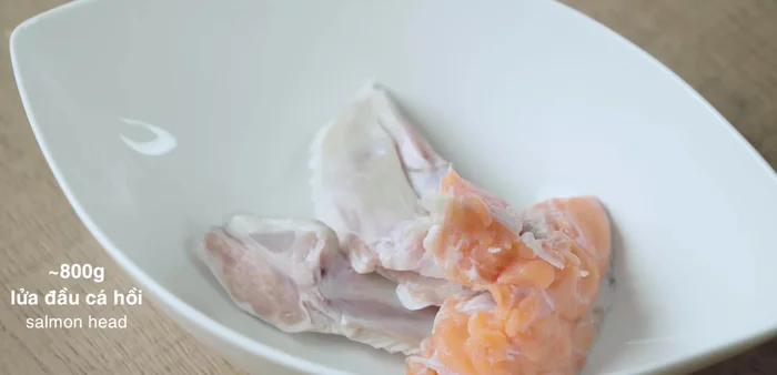 Ướp cá hồi với nửa muỗng canh dầu tỏi, 1 muỗng cà phê tỏi phi vàng, nửa muỗng canh nước mắm trong khoảng 10 phút.