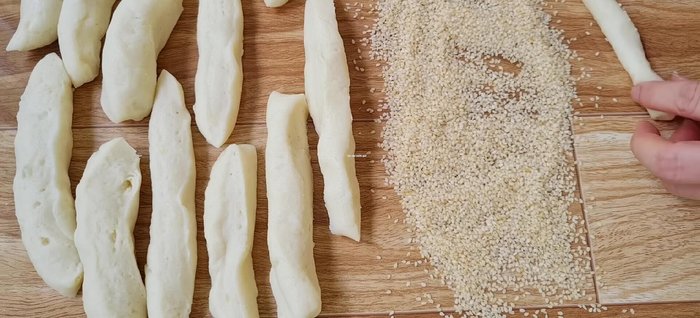 Chuẩn bị 100g bột màu trắng, rắc lên mặt phẳng. Lăn từng thanh bánh qua bột màu trắng cho đến khi đều màu.