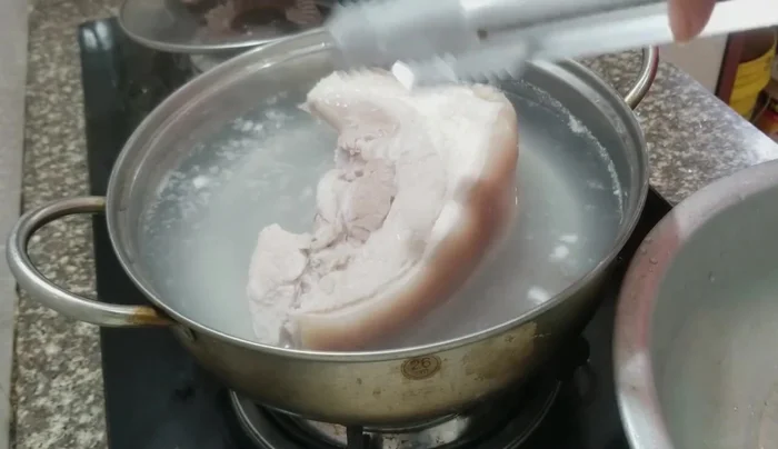 Vớt thịt ra, rửa sạch và dùng xiên đâm nhiều lỗ trên phần bì để khi chiên, bì sẽ giòn và nổ. (159.2, 201.739)