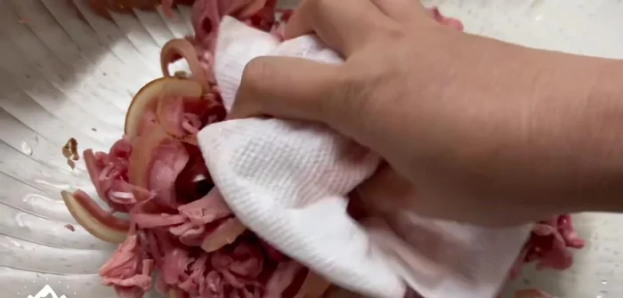 Trộn bê thui với thính, củ hành, rau ngò ôm.