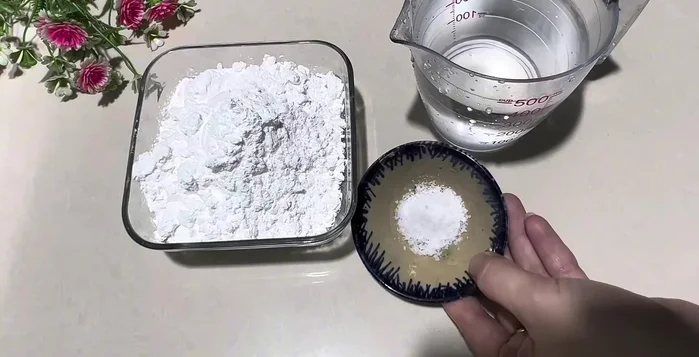 Trộn 200g bột năng, 400ml nước và một chút muối trong chảo. Khuấy đều. Để yên 10 phút.