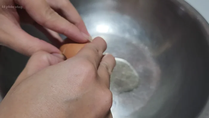 Đập 2 quả trứng gà vào thau, cho đường cát vào. Dùng máy đánh trứng đánh cho trứng và đường bông lên. (Đánh sơ cho đường tan trước khi dùng máy đánh trứng tốc độ cao)