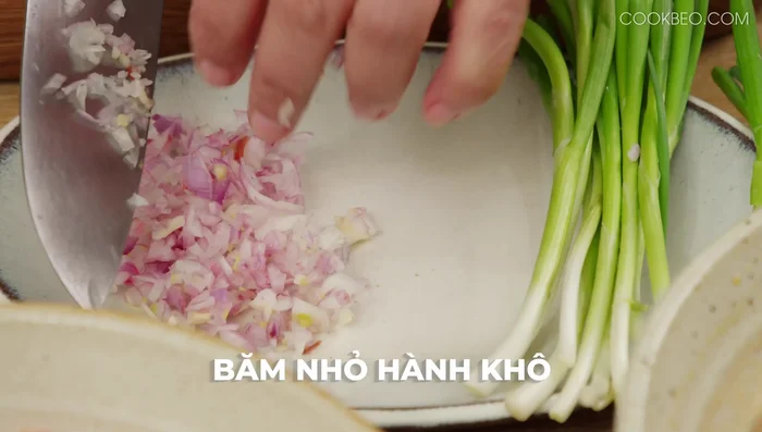 Băm nhỏ hành khô, cắt đầu hành lá thành khúc 1,5-2cm.