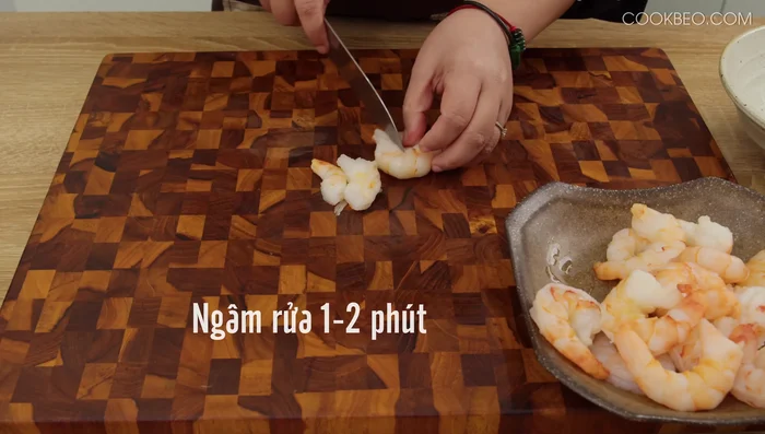 Ngâm rửa tôm nõn với nước muối loãng khoảng 1-2 phút để khử mùi tanh, sau đó rửa lại và để ráo. Cắt tôm thành miếng vừa ăn.
