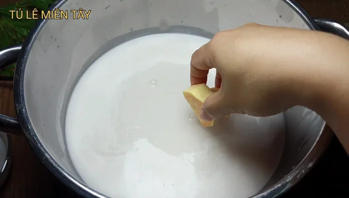 Cho nước cốt dừa vào nồi, đun sôi rồi cho khoai lang vào nấu khoảng 8 phút cho khoai mềm (287.09, 304.52).