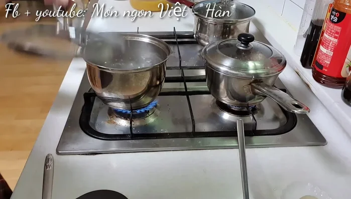Đun sôi đậu xanh, cho nước ép dành dành (hoặc phẩm màu/nghệ) và muối vào.