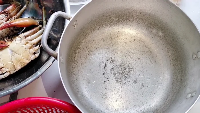 Cho muối hột vào nồi gang, dàn đều.