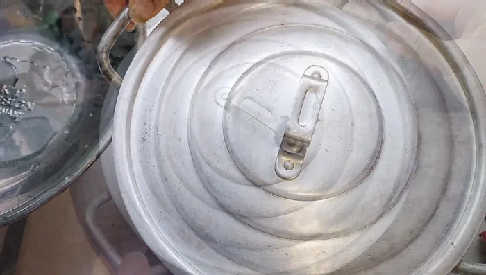 Đậy nắp nồi và hấp trên bếp than với lửa vừa trong 15 phút.