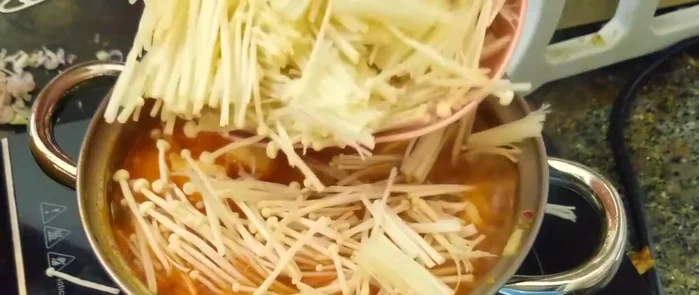 Cho nấm kim châm vào, đun sôi thêm 3 phút.