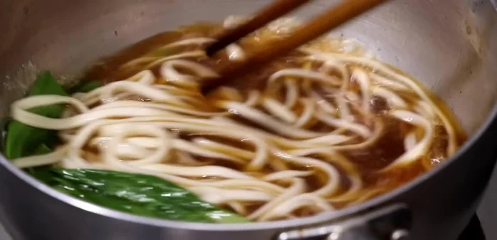 Hoàn thiện: Cho mì vào tô, chan nước dùng, thêm thịt bò, bắp bò, cải chua, hành lá, cải thìa, sa tế, tiêu.