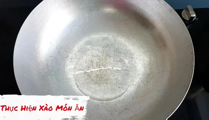 Phi thơm hành tỏi: Cho dầu ăn vào chảo, phi thơm hành tỏi.