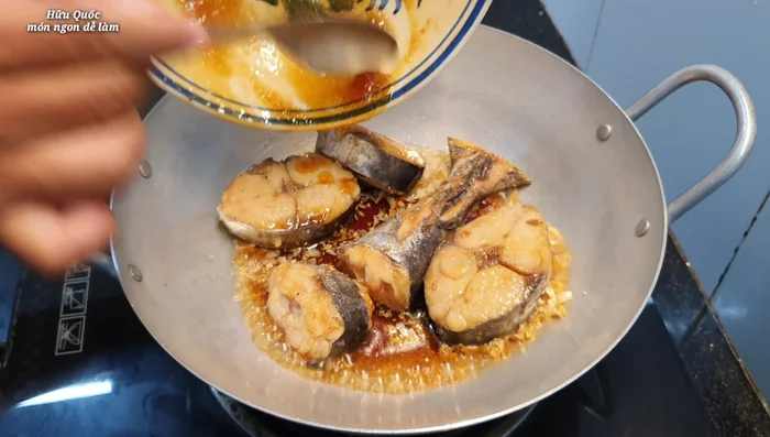 Cho cá thu đã ướp vào chảo, thêm nước lọc (khoảng hơn 1 chén). Kho đến khi cá chín vàng hai mặt. (393.8)