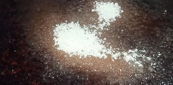 Khi nếp cẩm chín, cho 200g đường vào, khuấy đều cho đường tan. Lưu ý: Cho đường khi nếp cẩm còn nóng để đường tan đều và không ảnh hưởng đến chất lượng nếp.