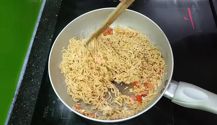 Cho mì vào, đảo đều với lửa to cho mì quyện với hỗn hợp.