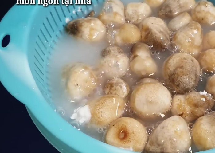 Rửa sạch nấm rơm với bột năng và nước, giúp nấm trắng và sạch hơn. Có thể thêm chút muối. Cắt bỏ phần gốc nấm.