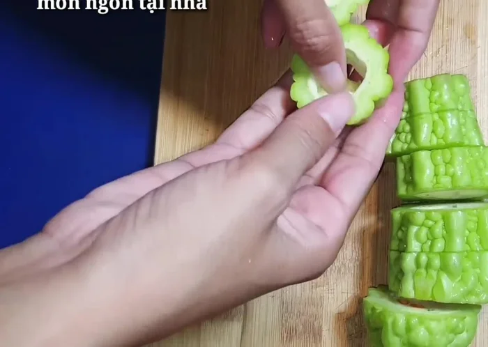Cắt bỏ phần đầu và ruột của khổ qua để giảm bớt vị đắng. Cắt khổ qua thành khúc vừa ăn và ngâm với nước muối pha loãng để giảm đắng.