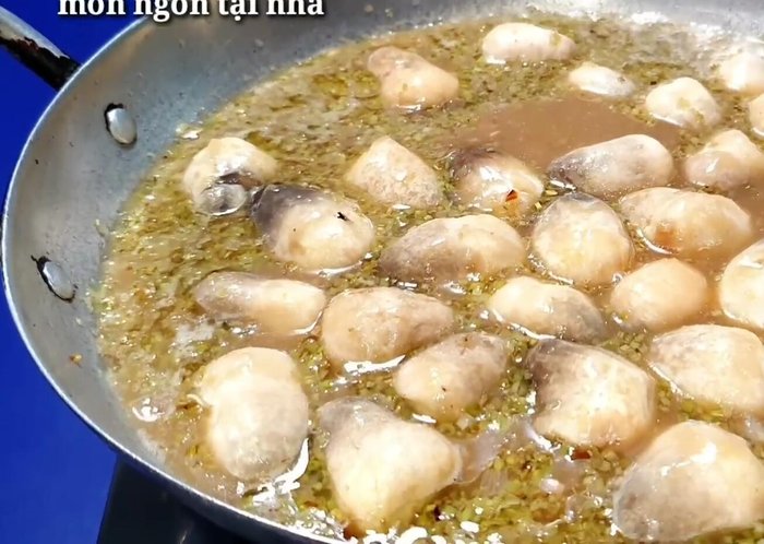 Đun sôi, vớt bọt. Cho nấm rơm vào trước, sau đó đến khổ qua. Nấu khoảng 5-6 phút.
