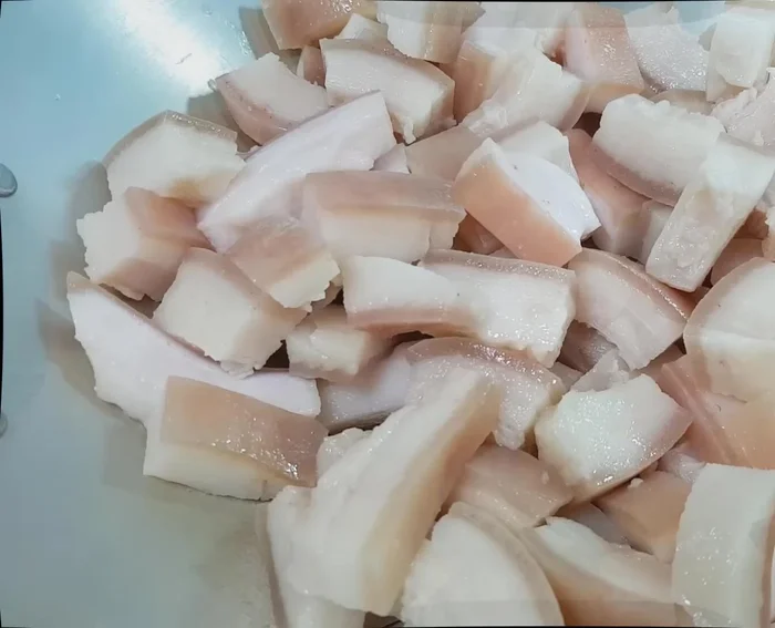 Cho tóp mỡ vào chảo, thêm 100ml nước lọc và 1 muỗng cà phê muối, đảo đều cho tóp mỡ không bị bắn dầu. Đảo liên tục đến khi tóp mỡ ra hết mỡ.