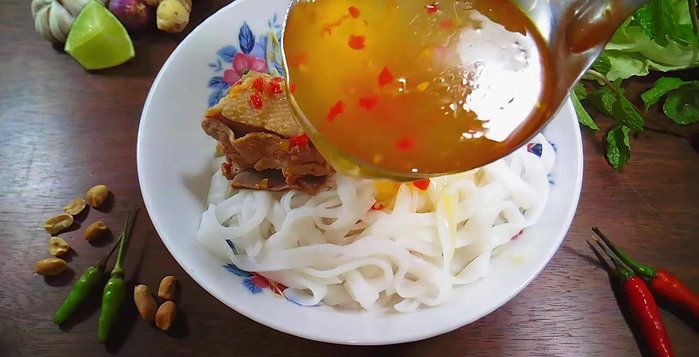 Cho thịt vịt, nước lèo vào tô mì. Thêm rau xà lách, rau húng lủi, đậu phộng rang, ớt xiêm xanh, chanh vào tô mì.